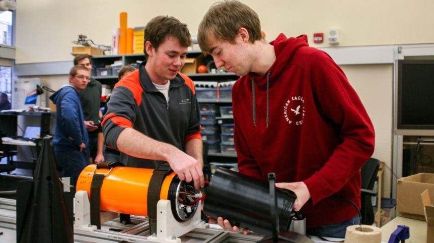 Two students are pictured in a lab, putting together pieces of the Javelin shell.