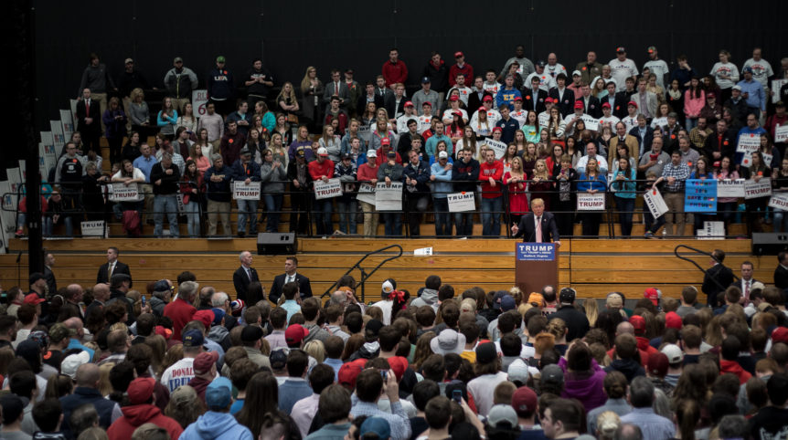 In the photo, soon-to-be President Donald Trump stands on a platform and speaks in front of a massive crowd of people.