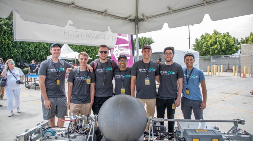 Seven students pose with a Hyperloop pod.