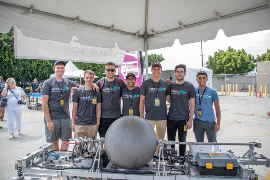 Seven students pose with a Hyperloop pod.