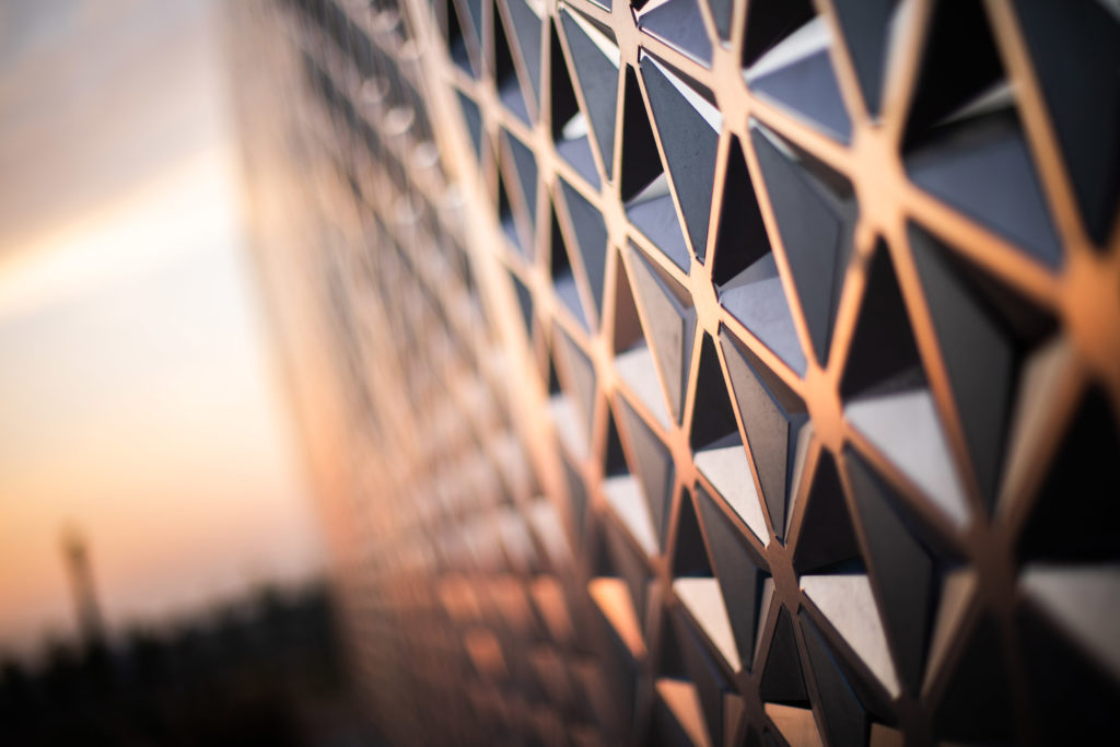 A photo of a geometric screen wall at sunset.