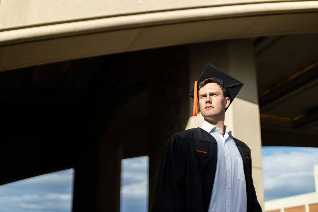 A photo of a young man looking off into the distance, wearing a graduation cap.